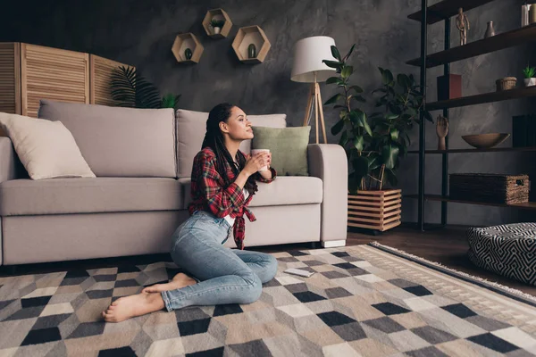 Retrato de chica soñadora atractiva sentada en la alfombra bebiendo café con leche descansando día de pasatiempo en el loft moderno casa industrial en el interior — Foto de Stock