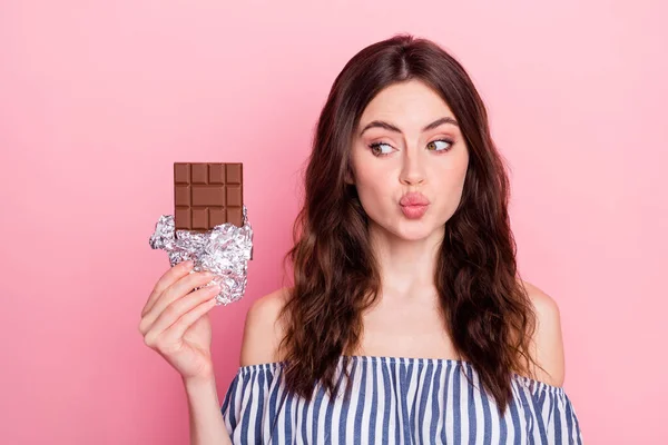 Foto van mooie optimistische brunette dame kijken chocolade blow kiss dragen blauwe jurk geïsoleerd op roze kleur achtergrond — Stockfoto