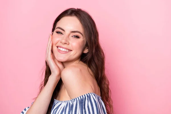 Foto van vrij charmante jonge vrouw gekleed gestreepte outfit glimlachende arm wang lege ruimte geïsoleerde roze kleur achtergrond — Stockfoto