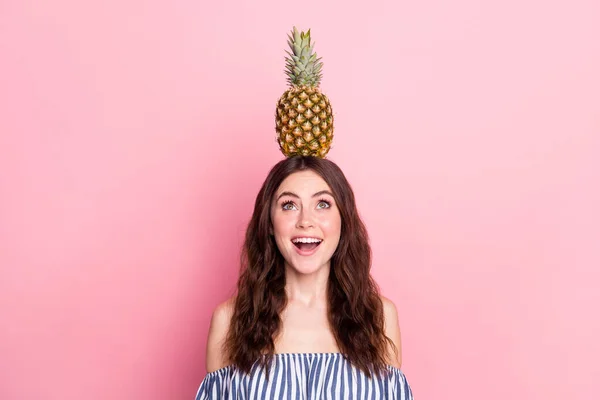 Foto de impactada bonita joven vestida a rayas traje sosteniendo fruta cabeza buscando espacio vacío aislado color rosa fondo —  Fotos de Stock