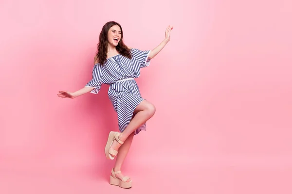 Foto de mulher muito adorável jovem vestida roupa listrada dançando olhando espaço vazio isolado cor de fundo rosa — Fotografia de Stock