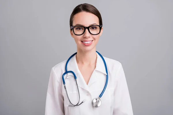 Foto retrato feminino médico com estetoscópio sorrindo usando óculos isolado fundo de cor cinza — Fotografia de Stock