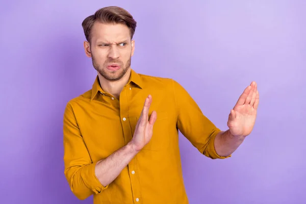 Portret van een aantrekkelijke trendy man tonen terzijde stop teken daling protest bescherming geïsoleerd over violet paarse kleur achtergrond — Stockfoto