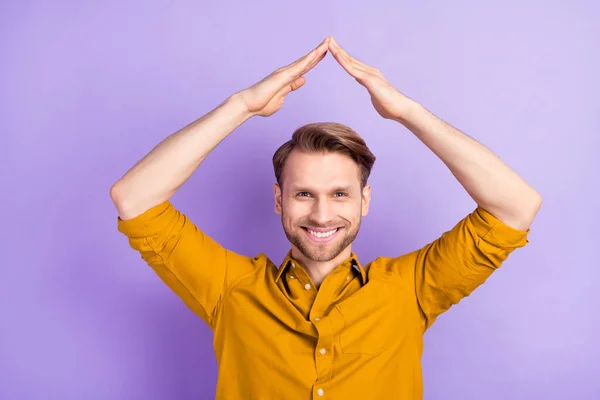 Ritratto di bel ragazzo attraente allegro mostrando tetto sopra la testa piatta isolato su viola sfondo colore viola — Foto Stock