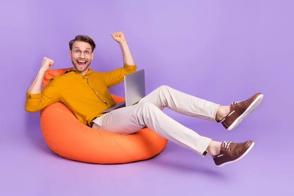 フルサイズプロフィール側の写真の若い男幸せな正の笑顔喜び勝利ラップトップ孤立以上紫の色背景 — ストック写真