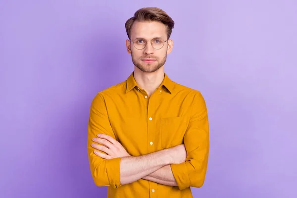 Zdjęcie cute ładny młody facet nosić casual okulary ubrania ramiona skrzyżowane odizolowane fioletowy kolor tła — Zdjęcie stockowe