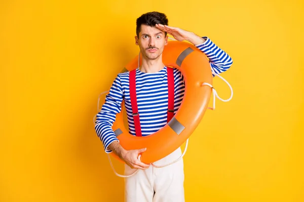 Foto de un joven marinero divertido funky serio cogido de la mano en la frente con boya en los hombros aislados en el fondo de color amarillo — Foto de Stock