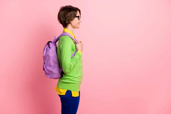 Foto di fiducioso intelligente giovane donna indossare occhiali cardigan verde zaino cercando spazio vuoto isolato colore rosa sfondo — Foto Stock