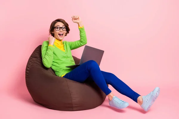Foto sisi profil wanita beruntung mengenakan kacamata kardigan hijau duduk kantong kacang teks perangkat modern terisolasi warna latar belakang merah muda — Stok Foto