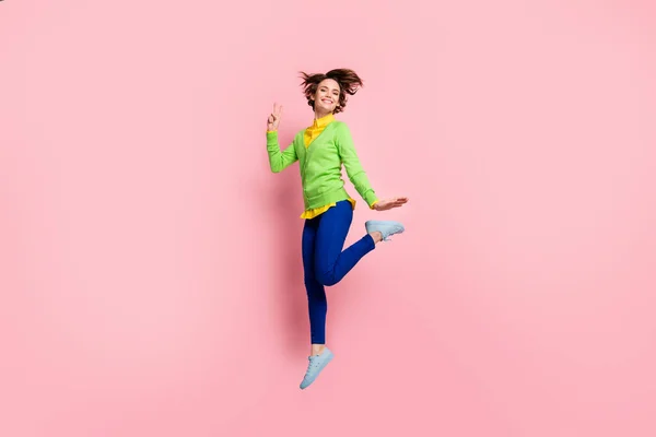 Foto de corpo inteiro de jovem ativa mulher feliz sorriso louco salto para cima mostrar oi paz fresco v-sinal isolado sobre fundo cor pastel — Fotografia de Stock