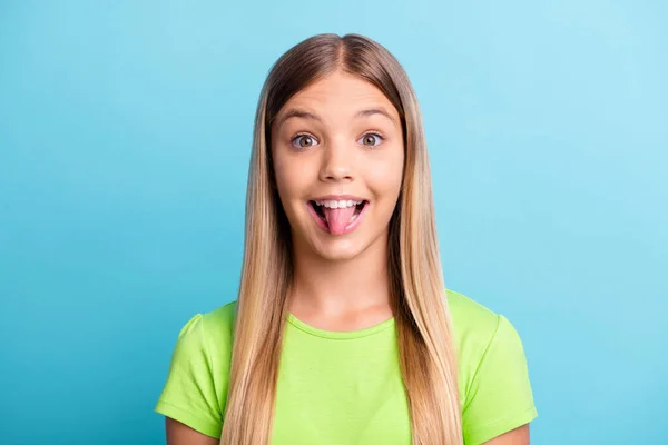 Foto de jovem muito doce bela menina alegre sorrindo furando a língua para fora isolado no fundo de cor azul — Fotografia de Stock