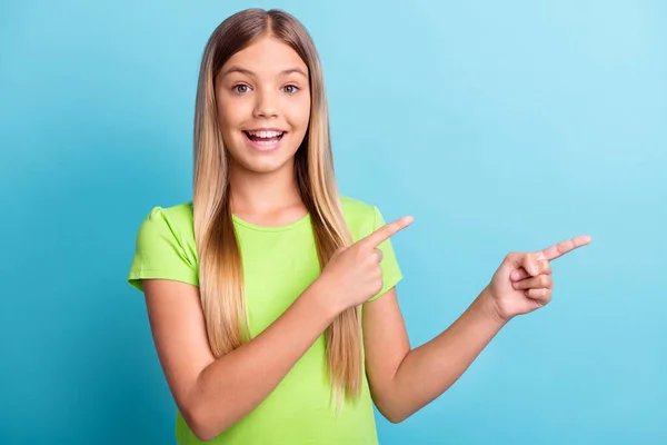 Φωτογραφία του νεαρού χαρούμενα καλή διάθεση θετική κορίτσι χαμογελώντας δείχνοντας τα δάχτυλα στο copyspace απομονώνονται σε μπλε φόντο χρώμα — Φωτογραφία Αρχείου