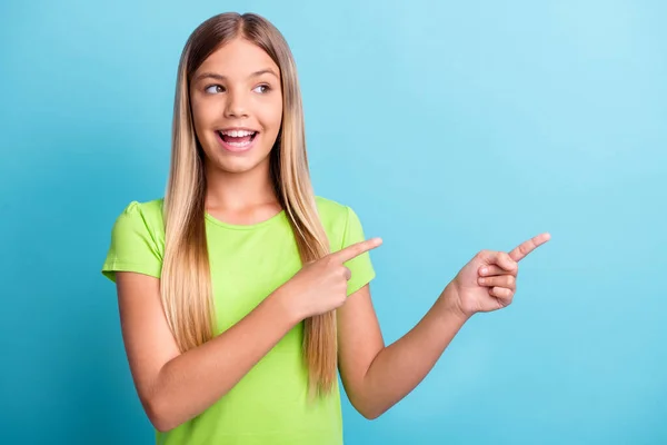 Foto de jovem alegre positivo bom humor sorridente menina apontando dedos copyspace isolado no fundo de cor azul — Fotografia de Stock