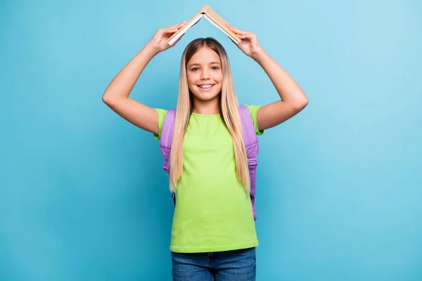 若い陽気な気分の写真正の笑顔の女の子学生ホールド本上の頭の上に隔離された青の色の背景 — ストック写真