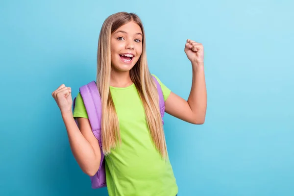 Foto de jovem alegre bom humor positivo sorrindo menina levantar punhos no exame de aprovação vitória isolado no fundo de cor azul — Fotografia de Stock