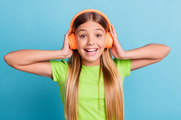 Foto av ung glad glad leende positiv flicka lyssna på musik bära orange hörlurar isolerad på blå färg bakgrund — Stockfoto