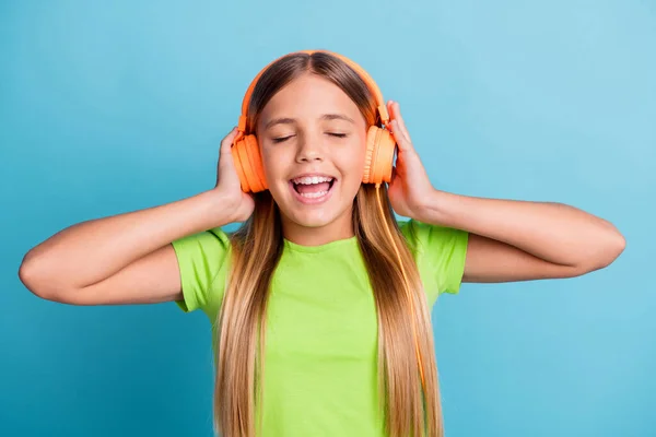 Photo of young happy smiling positive good mood girl wear orange headphones enjoying music isolated on blue color background — Foto de Stock