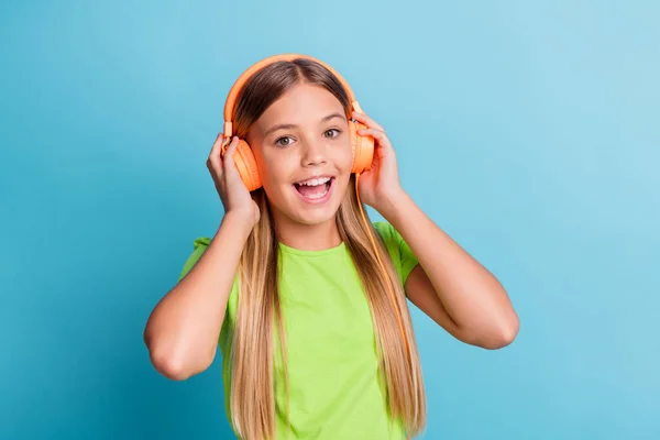 Foto von jungen glücklich fröhlich positive gute Laune Mädchen genießen Musik in orangen Kopfhörern isoliert auf blauem Hintergrund — Stockfoto