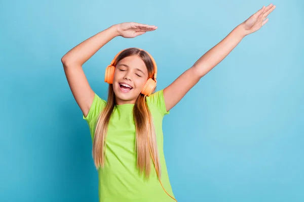 Zdjęcie młodego szczęśliwego uśmiechniętego pozytywnego nastroju dziewczyna korzystających muzyka taniec nosić pomarańczowy słuchawki odizolowane na tle niebieskiego koloru — Zdjęcie stockowe