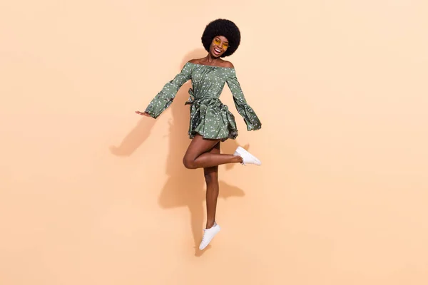 Photo of adorable pretty dark skin lady wear off-shoulders dress eyewear jumping high smiling isolated beige color background — Foto de Stock