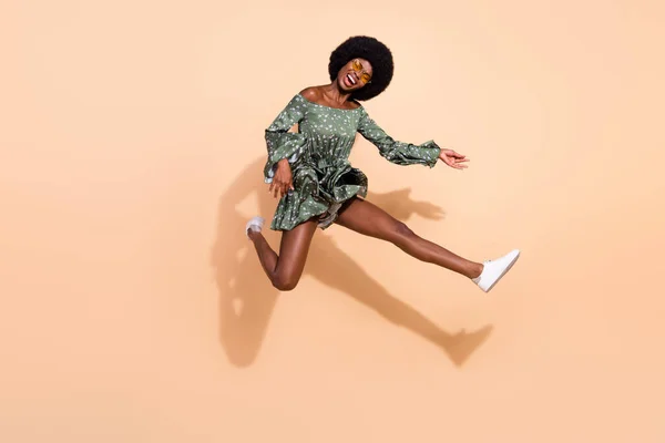 Full length profile side photo of young excited black girl happy positive smile jump play guitar isolated over beige color background