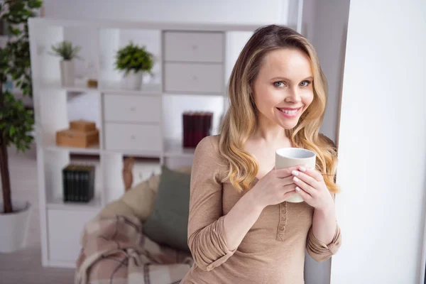 Foto van jonge aantrekkelijke vrouw gelukkig positieve glimlach genieten 's morgens kopje hete koffie pauze pauze thuis — Stockfoto