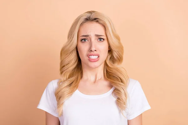 Foto retrato loira mulher nervosa com medo de roupa casual isolado pastel cor bege fundo — Fotografia de Stock