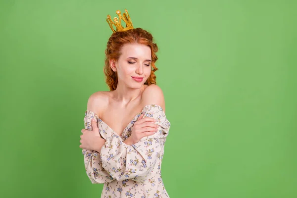 Foto de calma tranquila bastante feliz joven abrazo a sí misma llevar corona aislada sobre fondo de color verde —  Fotos de Stock