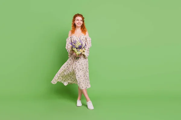 Полная длина фото мечтательной молодой счастливой женщины взгляд пустое пространство провести цветы изолированы на зеленом фоне цвета — стоковое фото