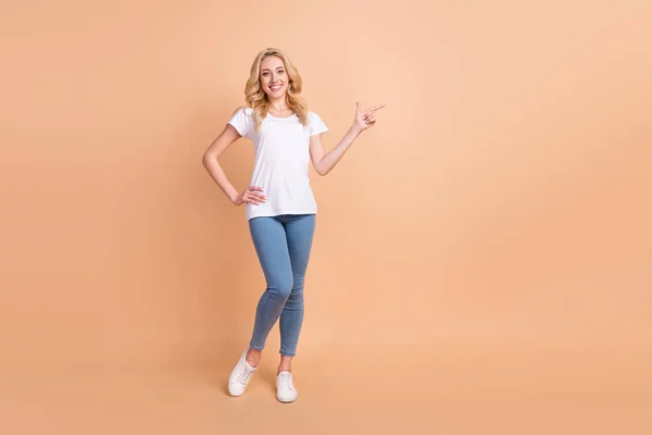 Volledige lengte body size foto blonde vrouw tonen copyspace geïsoleerde pastel beige kleur achtergrond — Stockfoto