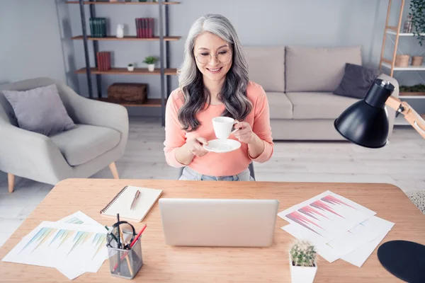 Portret van oudere gepensioneerde gepensioneerde vrolijke vrouw accountant marketeer werken op afstand espresso drinken in huis flat indoor — Stockfoto