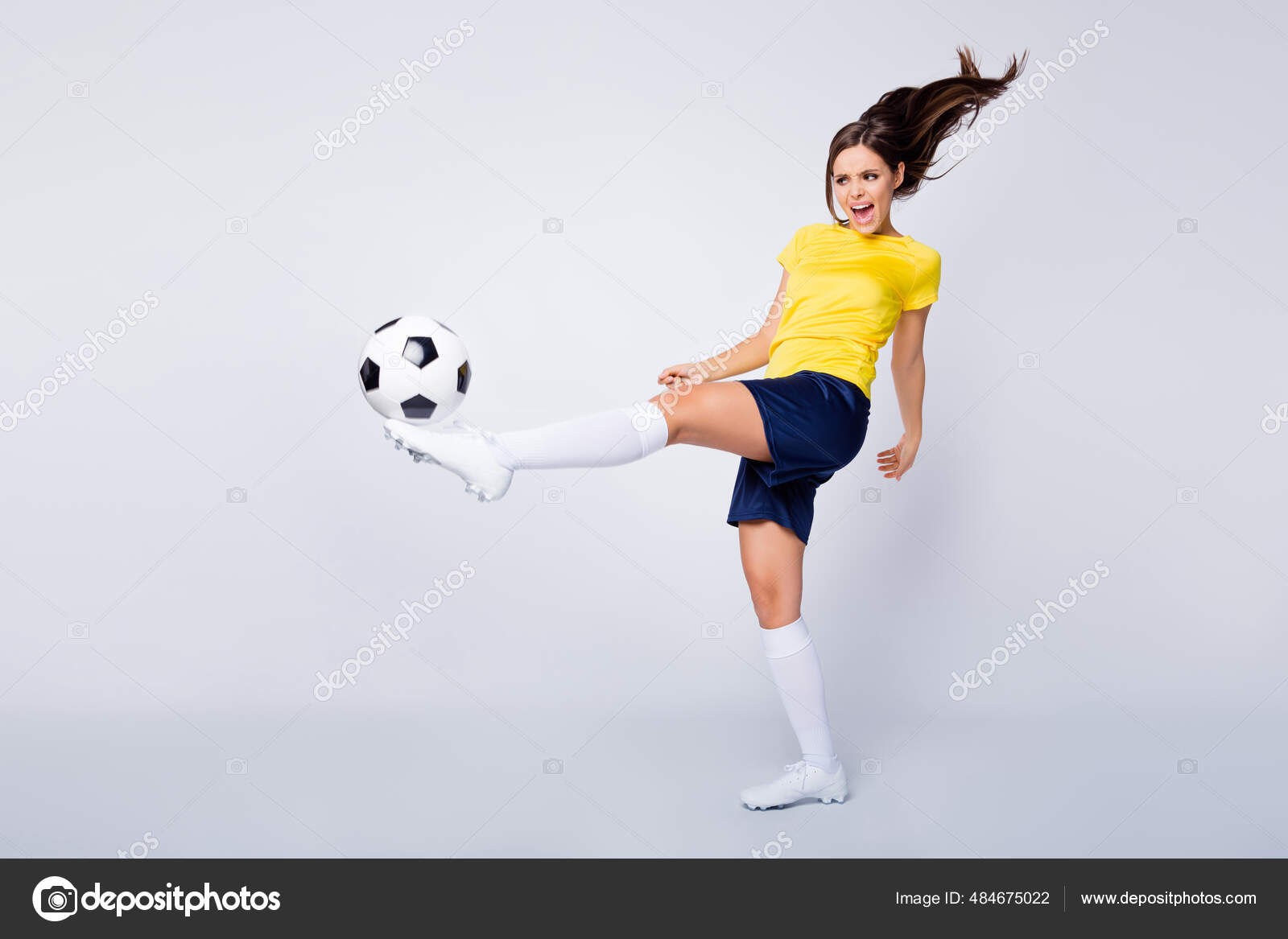 Jogador de futebol forte com bola de futebol no fundo branco isolado