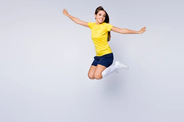 Фотографія повного розміру веселого професійного футболіста дівчина стрибає насолоджуватися грою у футбол чемпіонат світу з кубку одягу набір білих шкарпеток черевики ізольовані на сірому фоні — стокове фото