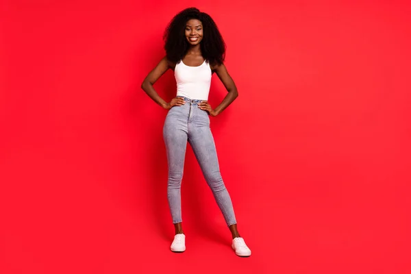Pełna długość zdjęcie młodej atrakcyjnej czarnej dziewczyny szczęśliwy pozytywny uśmiech pewny izolowany na czerwonym tle koloru — Zdjęcie stockowe