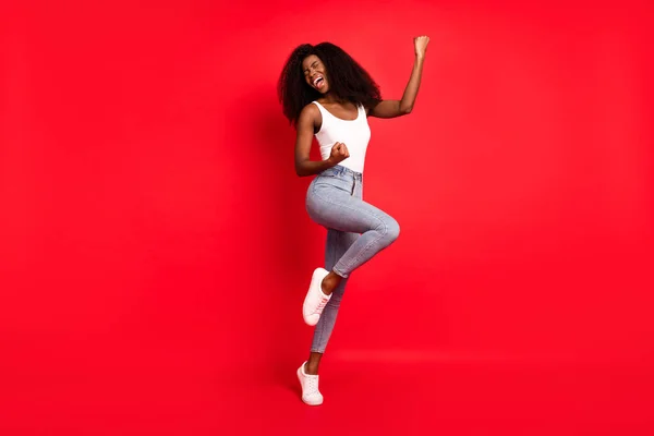 Foto de comprimento total de jovem atraente menina negra feliz sorriso positivo alegrar vitória vitória isolada sobre fundo de cor vermelha — Fotografia de Stock