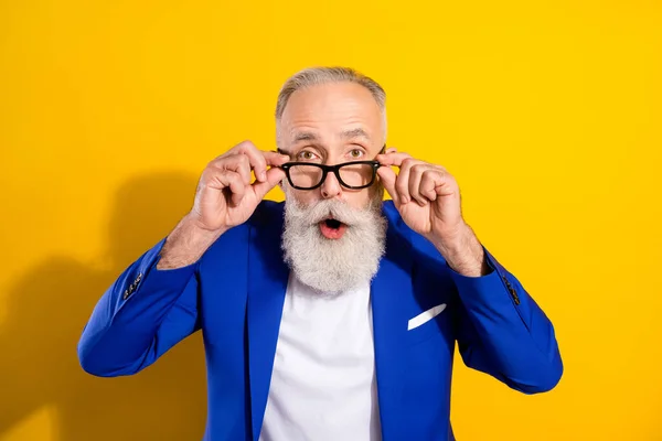 Portrait photo d'un homme sénior étonné portant des lunettes costume bleu regardant isolé sur fond jaune vif — Photo