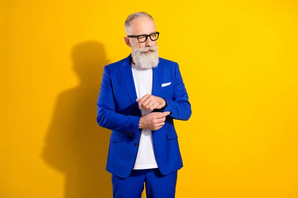 Photo portrait of businessman wearing blue suit adjusting buttons in eyewear isolated on vivid yellow color background — Stock Photo, Image