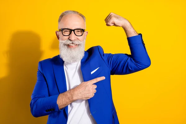 Портрет привабливого веселого чоловіка, що демонструє м'язи ізольовані на яскраво-жовтому кольоровому фоні — стокове фото