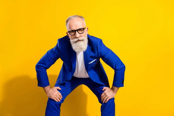 Photo de stricte barbe grise homme âgé regarder vous portez lunettes veste bleue isolé sur fond de couleur jaune vif — Photo