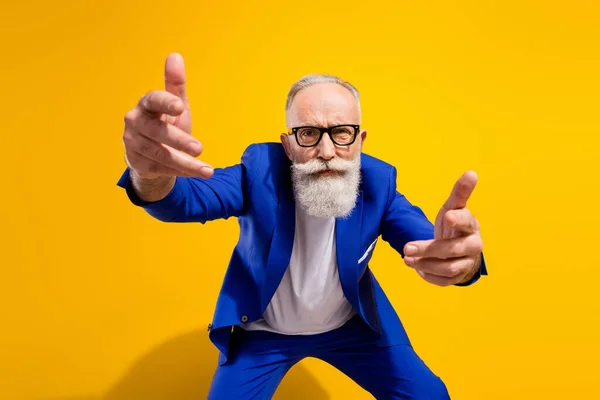 Фото нещасного злий старий вказує, що ви строго носите окуляри синій костюм ізольовані на блискучому жовтому тлі — стокове фото