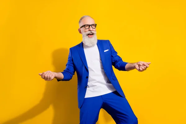 Foto de barba cinza funky homem sênior olhar espaço vazio desgaste óculos casaco azul isolado no fundo de cor amarelo vívido — Fotografia de Stock