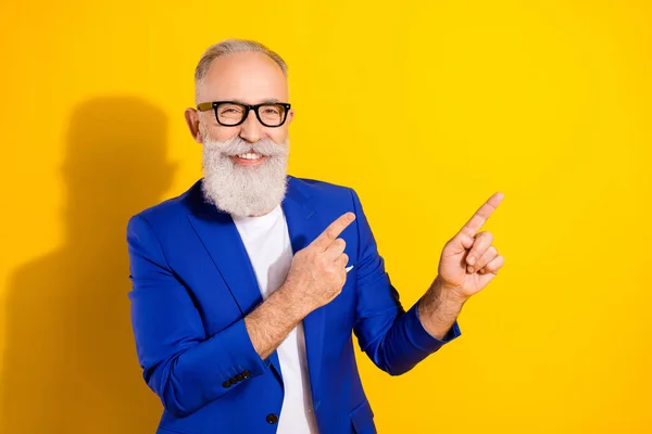 Photo de attrayant jeune homme heureux charmant pointe des doigts espace vide sourire isolé sur fond de couleur jaune — Photo