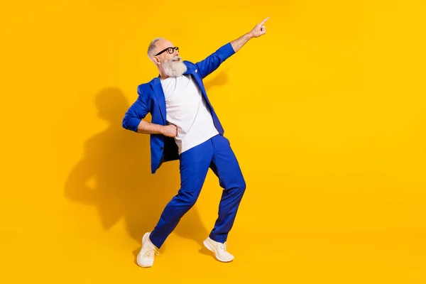 Foto de perfil em tamanho completo de barba cinza engraçada homem envelhecido óculos de dança casaco azul isolado no fundo amarelo — Fotografia de Stock