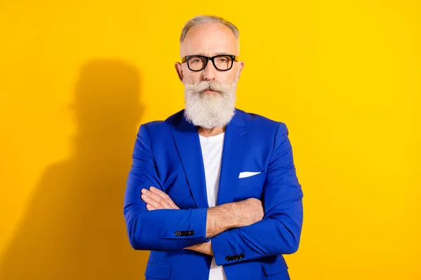 Foto de empresário representativo legal e confiante sério em óculos com braços cruzados isolados em fundo de cor amarela — Fotografia de Stock