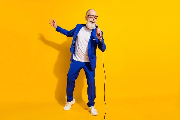 Full size foto van vrolijke vrolijke goed humeur volwassen zakenman zingen karaoke geïsoleerd op gele kleur achtergrond — Stockfoto