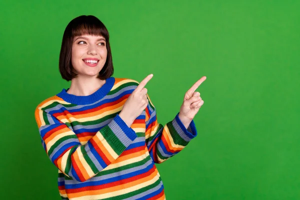 Fotografie atraktivní šťastný pozitivní mladá žena vzhled bod prsty prázdný prostor informace izolované na zeleném pozadí — Stock fotografie