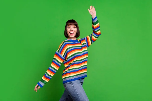 Fénykép vidám szép fiatal pozitív nő integetett hello hand walk mosoly jó hangulat elszigetelt zöld színű háttér — Stock Fotó