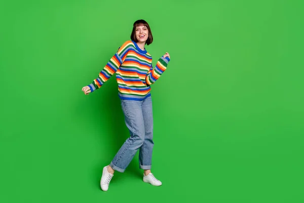 Plná délka fotografie funky rozkošná mladá žena nosit pruhované svetr s úsměvem tanec izolované zelené barvy pozadí — Stock fotografie