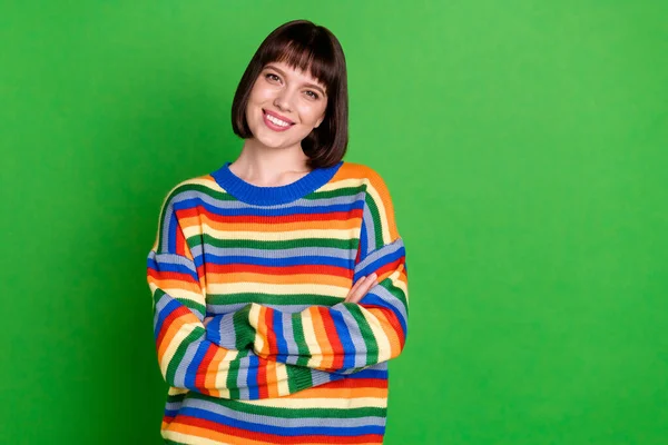 Foto de muito adorável jovem mulher usar listrado suéter sorridente braços cruzados espaço vazio isolado cor verde fundo — Fotografia de Stock