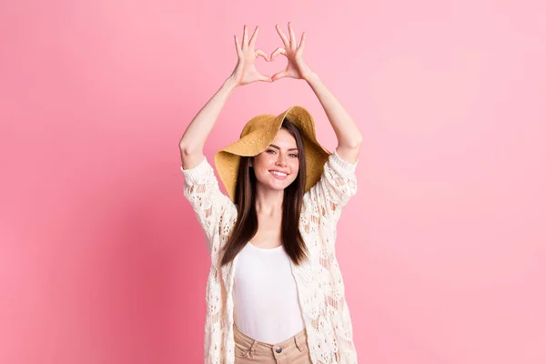 Foto de encantadores dedos amistosos de la persona hacen mostrar el símbolo del corazón por encima de la cabeza aislado en el fondo de color rosa — Foto de Stock